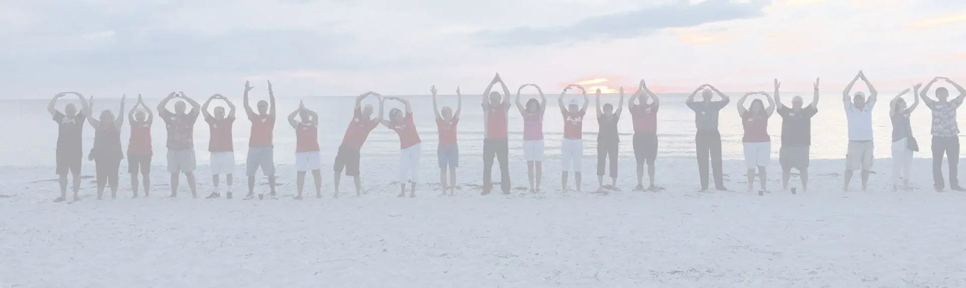 Members spelling O-H-I-O on the beach at sunset